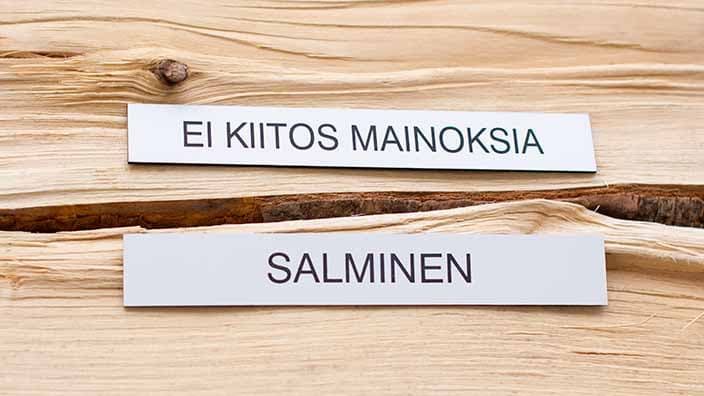 Valkoinen postilaatikkokilpi kaiverretulla tekstillä